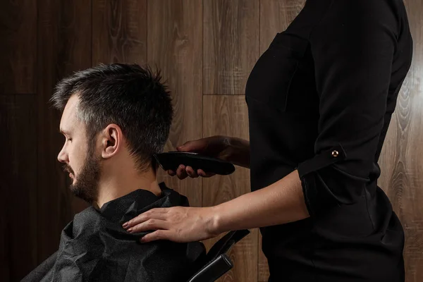 O mestre faz um corte de cabelo ao cliente com uma máquina elétrica, cortador, close-up. O processo de cortes de cabelo masculinos no cabeleireiro, barbearia. Cuidados com o corpo, estilo de vida, metrosexual . — Fotografia de Stock