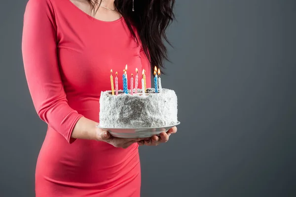 Дівчина в рожевій сукні тримає в руках торт з палаючими свічками, крупним планом. З днем народження привітання з святом вечірки. Копіювати простір . — стокове фото