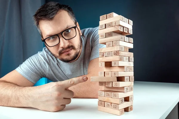 Adam Jenga Sütunu 'nu işaret ediyor. İpotek, yatırım riskleri, ekonomik kriz, ekonomik istikrarsızlık kavramı. — Stok fotoğraf