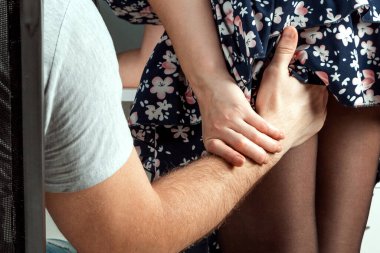 A male hand climbs a girl under a skirt. Touch the ass and leg of an office girl. He is sexually abusing. Women are sexually abused. Sexual abuse concept, victim
