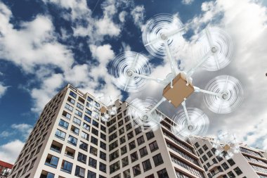 Gökyüzü arka planında karton kutusu olan beyaz uçan bir dron. Dron teslimat için. Hızlı dağıtım konsepti, teknoloji. Boşluğu kopyala