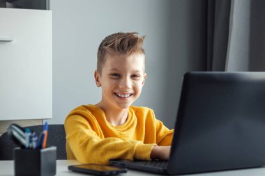 Uzaktan öğrenme, bir çocuk online ders sırasında dizüstü bilgisayara bakarken matematik öğreniyor. Çevrimiçi eğitim, ev eğitimi, teknoloji, karantina, kendini izole etme kavramı