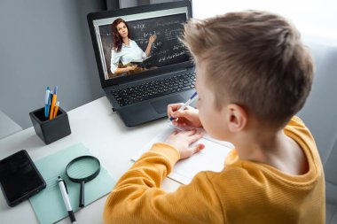 Uzaktan öğrenme, bir çocuk online ders sırasında dizüstü bilgisayara bakarken matematik öğreniyor. Çevrimiçi eğitim, ev eğitimi, teknoloji, karantina, kendini izole etme kavramı