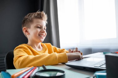 Uzaktan öğrenme, bir çocuk online ders sırasında dizüstü bilgisayara bakarken matematik öğreniyor. Çevrimiçi eğitim, ev eğitimi, teknoloji, karantina, kendini izole etme kavramı