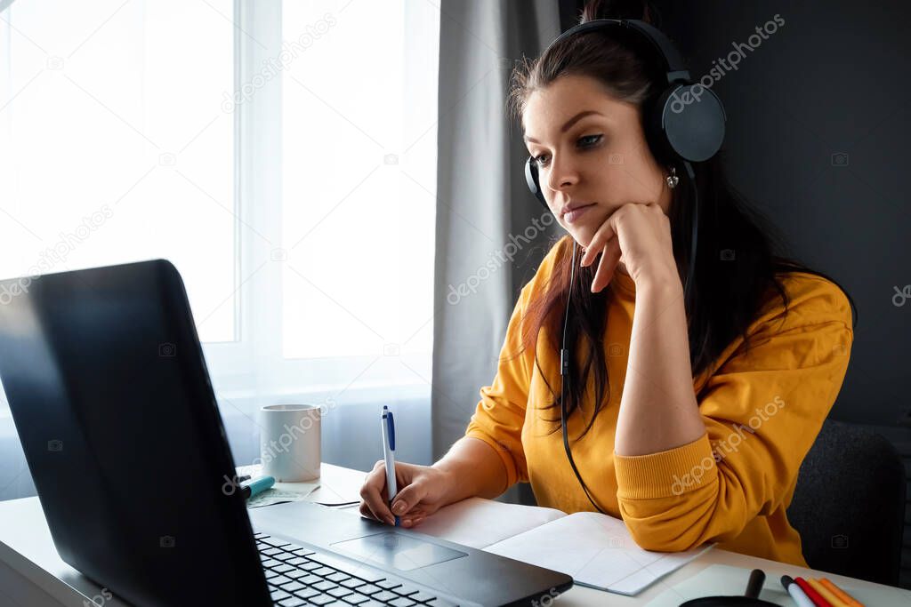 Beautiful girl using laptop working at home, concept of online work, remote work. Watching a webinar, looking for friends on social networks. Modern technologies