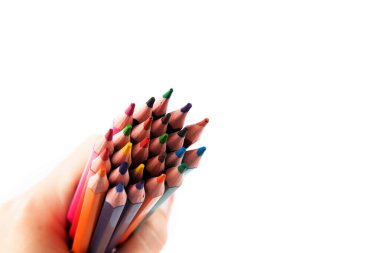 Eldeki renkli kalemler beyaz arkaplanda izole edilmiş. Yaratıcı arkaplan, kopyalama alanı