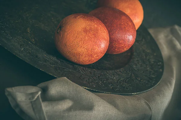 Кровавые апельсины на деревенском и сером фоне — стоковое фото