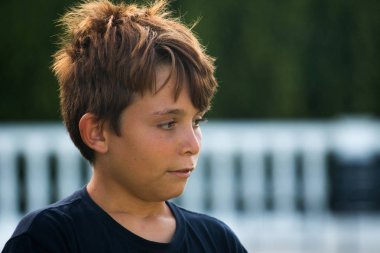 Yaz zamanı sırasında bir bahçede preadolescent gülümseme pozlar