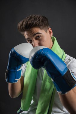 Genç boksör iki tonlu eldiven ve havlu boyun Studio fotoğraf çekimleri için poz