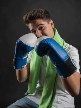 Genç boksör iki tonlu eldiven ve havlu boyun Studio fotoğraf çekimleri için poz