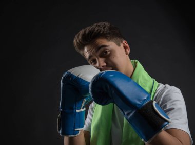 Genç boksör iki tonlu eldiven ve havlu boyun Studio fotoğraf çekimleri için poz