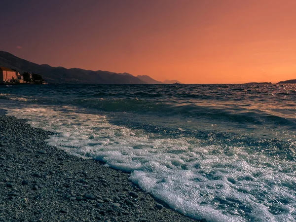 Волны, прибывающие на побережье на закате — стоковое фото