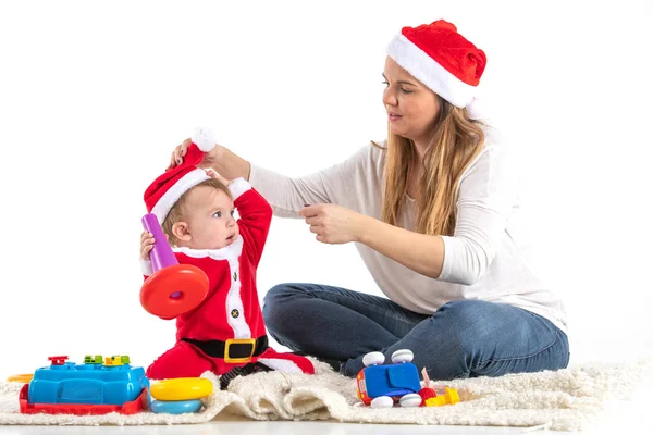 Estúdio foto com um fundo branco de uma mãe e criança vestida para Saint Claus jogando . — Fotografia de Stock