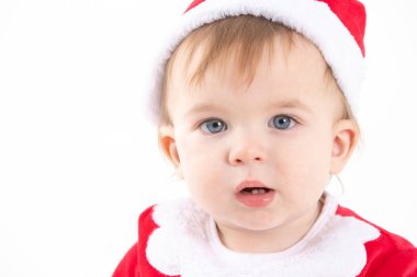 Noel Baba kılığında bir bebeğin portresinin beyaz arkaplanlı stüdyo fotoğrafı.