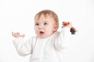 Elindeki oyuncakla kollarını kaldırmış bir bebek