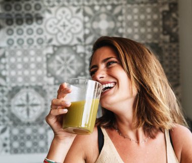 Kafkasyalı kız önünde yeşil sebze suyu içiyor.