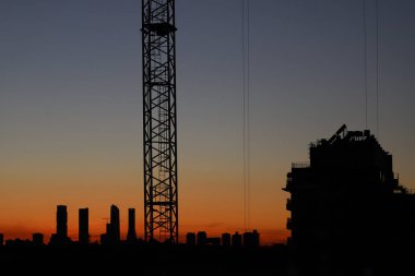 image of the sunset in the Valdebebas neighborhood in Madrid. Area under construction with mounted cranes