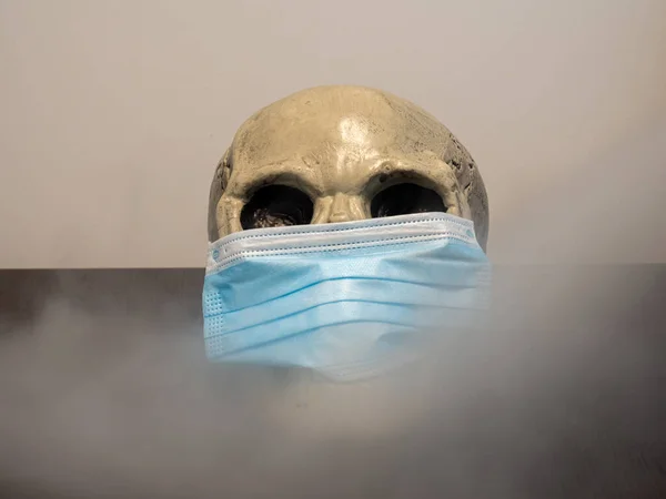 Skull wearing a mask and surrounded by tobacco smoke