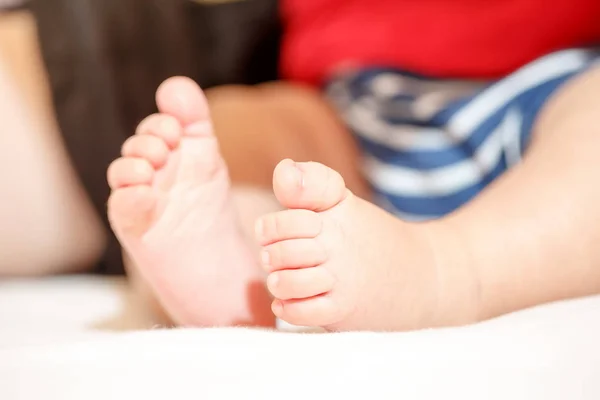 白い背景で隔離床に座って美しい赤ちゃん足のクローズ アップ — ストック写真