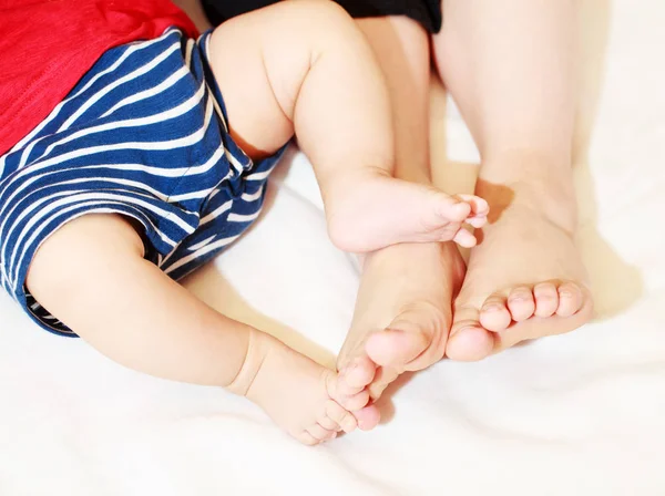 Family on the bed at home with their feet showing