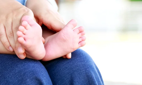 Маленькие ножки в руках матери — стоковое фото