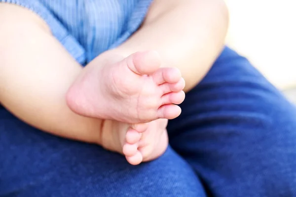 Baby's feet on mother's knees — Stock Photo, Image