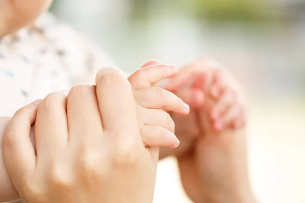 Семейная сцена, родитель крупным планом и ребенок держатся за руку — стоковое фото