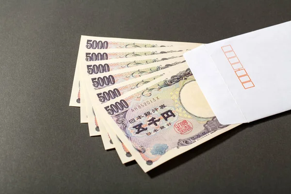 Busta bianca e banconota giapponese 5000 yen — Foto Stock