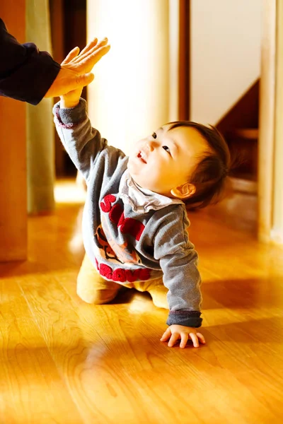 Hermoso niño arrastrándose por el suelo. y él choca los cinco con su padre . —  Fotos de Stock