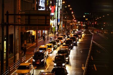 Geceleri işlek bir şehir yolda trafik ışıkları.