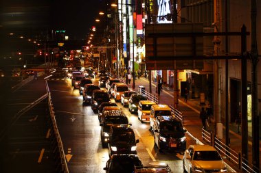 Geceleri işlek bir şehir yolda trafik ışıkları.