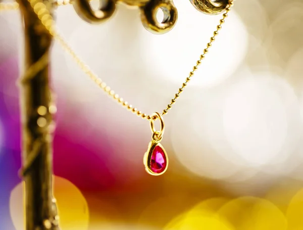 Arany nyaklánc ruby színes háttérrel. — Stock Fotó