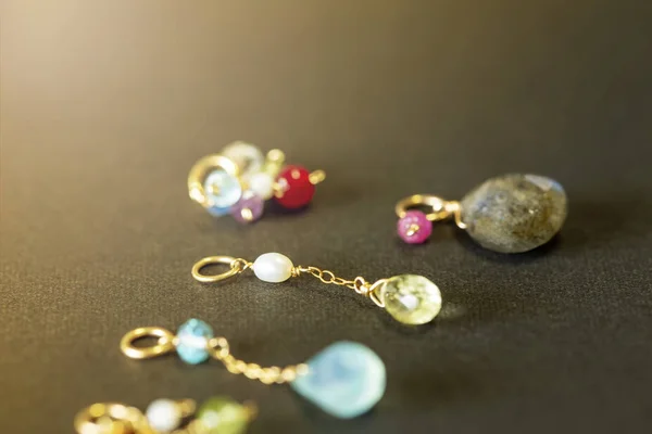 lemon quartz, ruby, pearl,labradorite,apatite, green chalcedony, blue topaz necklace charm isolated on black background.close up.