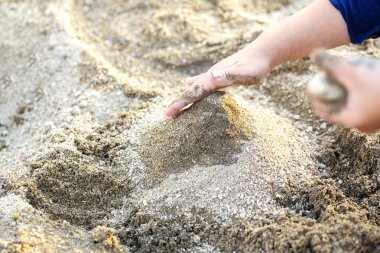 Kum ve kopyalama alanı ile oynayan çocuk elleri ve boşluk.