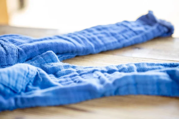 Los pantalones azules tirados sobre la mesa de madera . — Foto de Stock