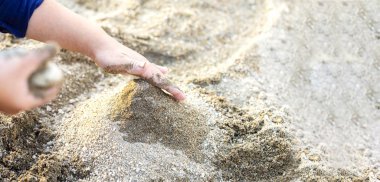 Kum ve kopyalama alanı ile oynayan çocuk elleri ve boşluk.