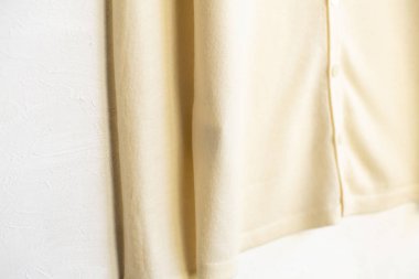 Beyaz elbiseli bir hırka beyaz arka planda asılı..