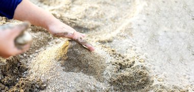 Kum ve kopyalama alanı ile oynayan çocuk elleri ve boşluk.