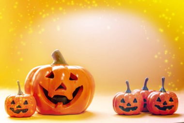 Birçok gülümseyen portakalların kabakları ve parlak arkaplanlı büyük bir balkabağı ve kopyalama alanı ve ışıl ışıl parlayan renklerle dolu.