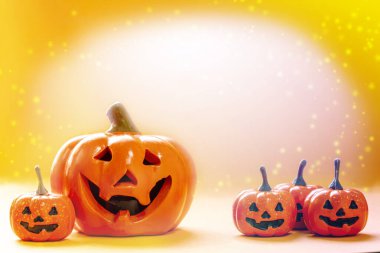 Birçok gülümseyen portakalların kabakları ve parlak arkaplanlı büyük bir balkabağı ve kopyalama alanı ve ışıl ışıl parlayan renklerle dolu.