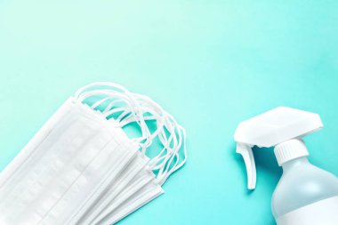 Mavi arkaplanda tıbbi maske ve antiseptik solüsyon seti ve kopyalama alanı.