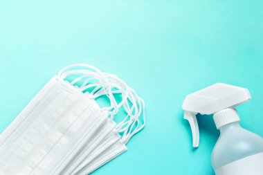 Mavi arkaplanda tıbbi maske ve antiseptik solüsyon seti ve kopyalama alanı.