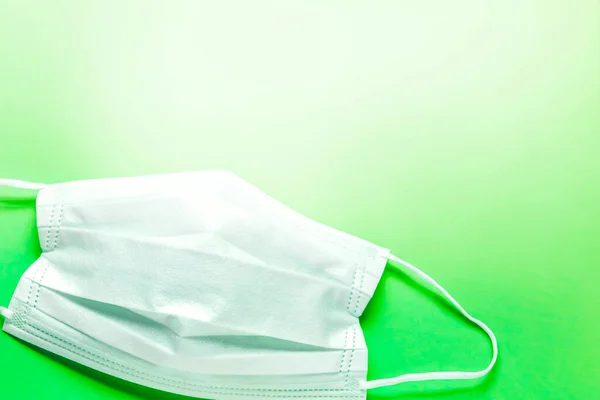 Jednoduchá Bílá Ochranná Maska Barevném Povrchu Zeleném Pozadí Jednorázová Chirurgická — Stock fotografie