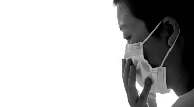 Genç bir kadın renk yüzeyine basit bir beyaz hava koruma maskesi takıyor. Grip, ateş, salgın, salgın belirtileri. Profil görünümü ve siyah ve beyaz.