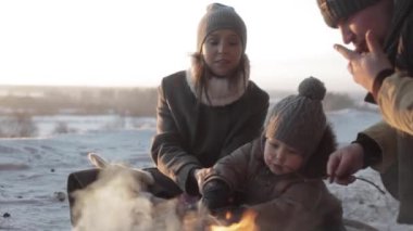 Baba, anne kavurma marshmallow kış ormandaki küçük bir oğlu