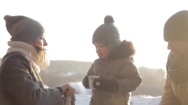 가족 겨울 숲에서 산책 하는 동안 뜨거운 차를 즐긴다 — 비디오