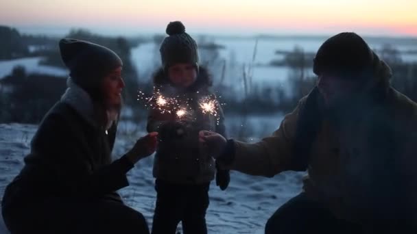 Famille avec garçon et étincelles dans la forêt d'hiver — Video