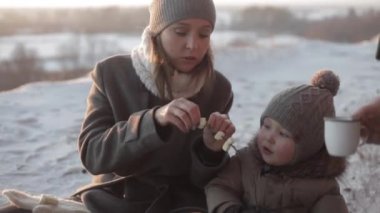 Baba, anne kavurma marshmallow kış ormandaki küçük bir oğlu
