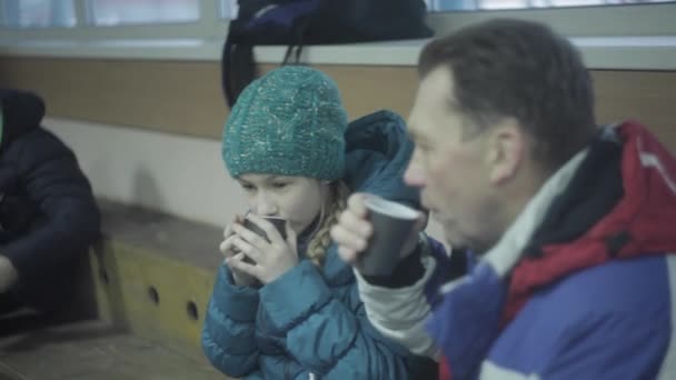 Vater und Tochter trinken nach Eislaufen heiße Schokolade — Stockvideo