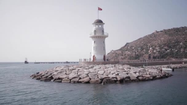 Faro turco in mare con montagna sullo sfondo — Video Stock